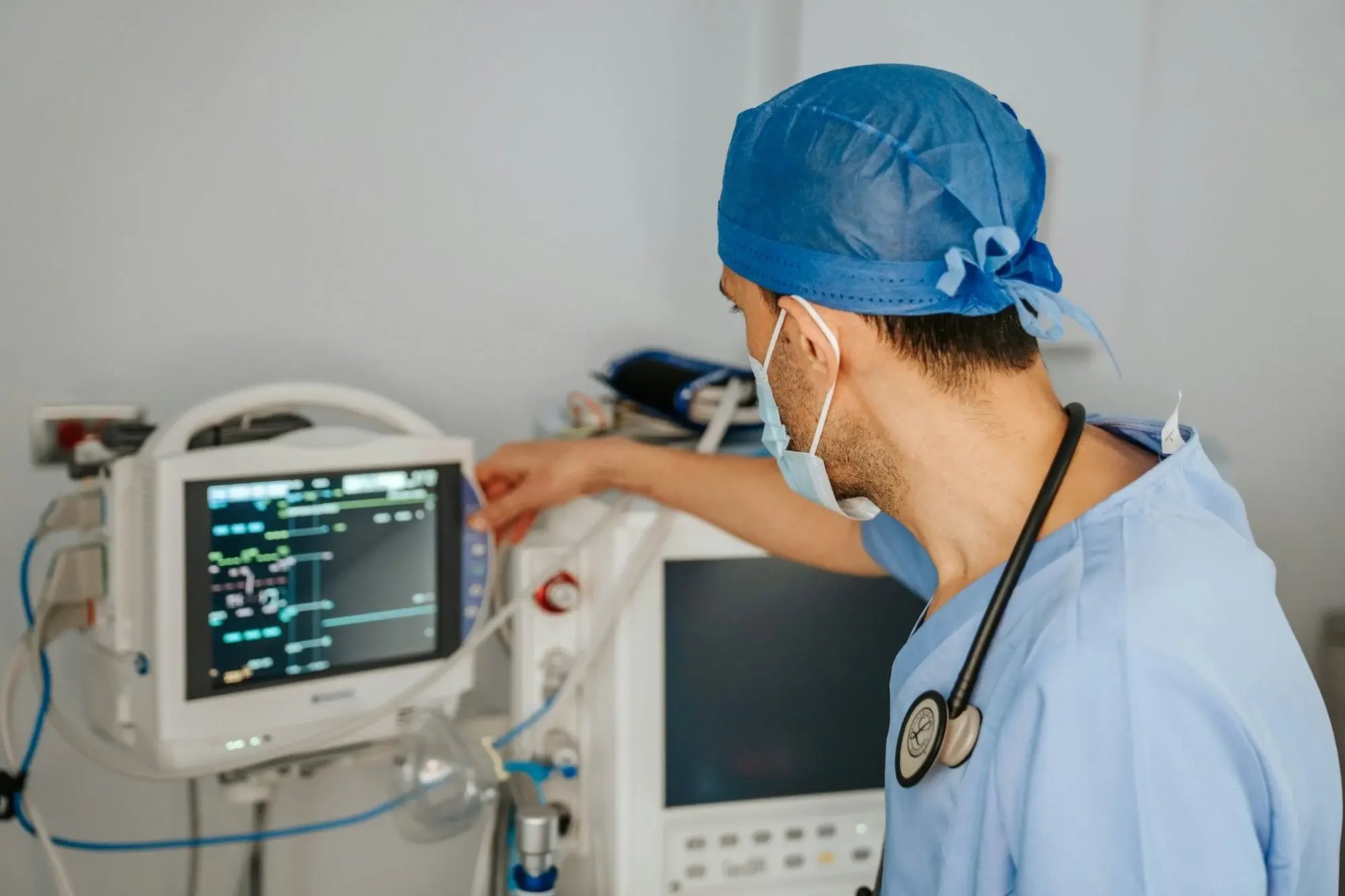 Profissional de saúde ajusta um monitor de sinais vitais em um quarto de hospital